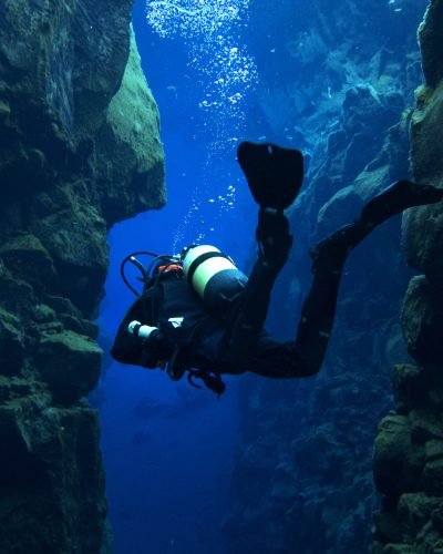 Scuba Diving at Silfra, Iceland in Dry Suits at the Continental Divide at the Þingvellir National Park in Iceland. Glacial runoff water (fresh water). 0 Celsius.